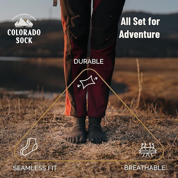 Person wearing maroon pants and charcoal socks with text highlighting features like durability, seamless fit, and breathability.