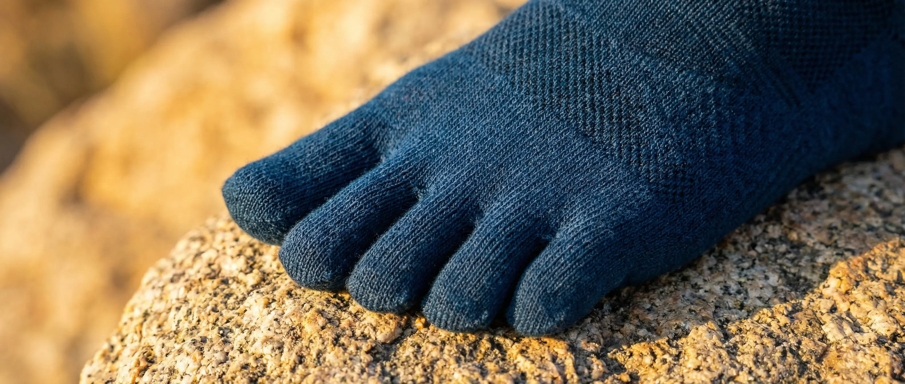 Close-up of a navy merino toe sock on sun-warmed granite (Colorado Sock Co. on Amazon)