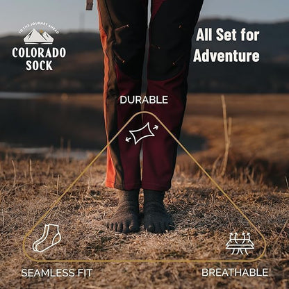 Person wearing maroon pants and charcoal socks with text highlighting features like durability, seamless fit, and breathability.